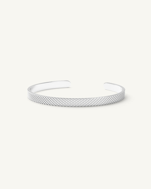 A polished stainless steel bangle in silver from Waldor & Co. One size. The model is Grid Bangle Polished.
