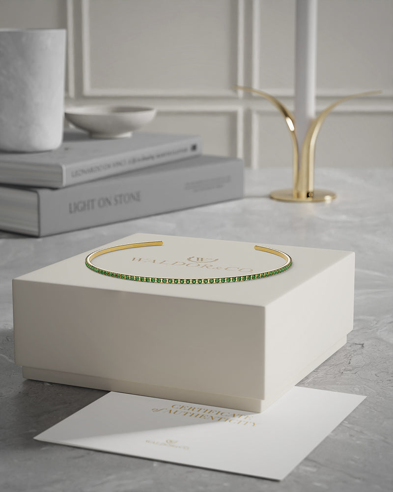 A Bangle in 14k gold-plated 316L stainless steel with green stones from Waldor & Co. One size. The model is Dulcet Bangle Polished.