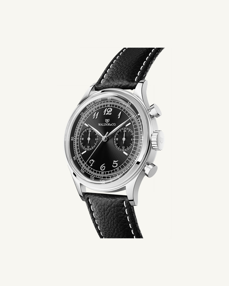 A round mens watch in Rhodium-plated 316L stainless from Waldor & Co. with black sunray dial. Curved mineral glass with 5 layers anti-reflective coating. Seiko VD32 movement. Genuine leather strap. The model is Avant 39 Eze.