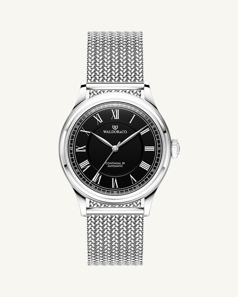 A round Automatic mens watch in Rhodiun plated 316L stainless from Waldor & Co. wit black double-layered dial in copper. Curved mineral glass with anti-reflective coating.Miyota 9093 movement. Mesh strap. The model is Continual 39 Amalfi.