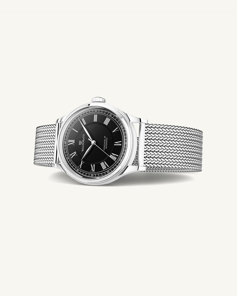 A round Automatic mens watch in Rhodiun plated 316L stainless from Waldor & Co. wit black double-layered dial in copper. Curved mineral glass with anti-reflective coating.Miyota 9093 movement. Mesh strap. The model is Continual 39 Amalfi.