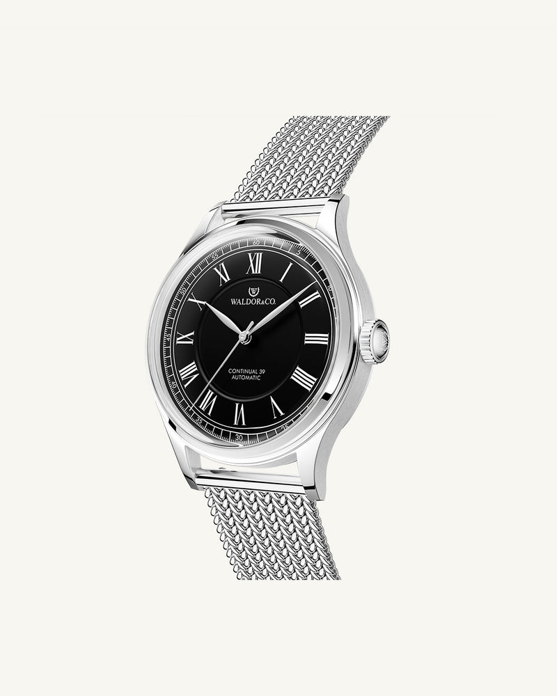 A round Automatic mens watch in Rhodiun plated 316L stainless from Waldor & Co. wit black double-layered dial in copper. Curved mineral glass with anti-reflective coating.Miyota 9093 movement. Mesh strap. The model is Continual 39 Amalfi.