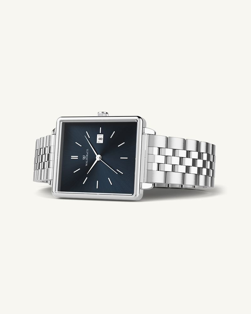 A square womens watch in silver from WALDOR & CO. with blue sunray dial and a second hand. The model is Delight 32 Chelsea 28x32mm.