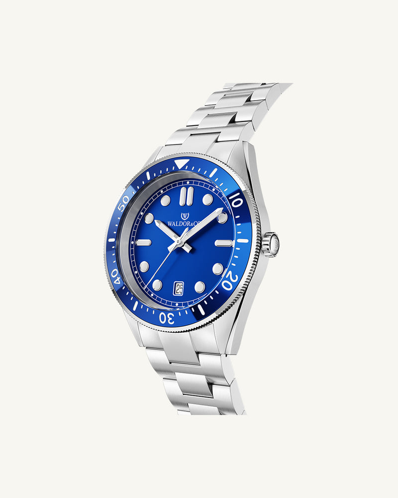 A round mens watch in Rhodium-plated 316L stainless steel from Waldor & Co. with Blue dial in brass with a rotating bezel. Applied indices, luminous hands. Ronda 715. The model is Novel 40 Cap d’Ail 40mm.
