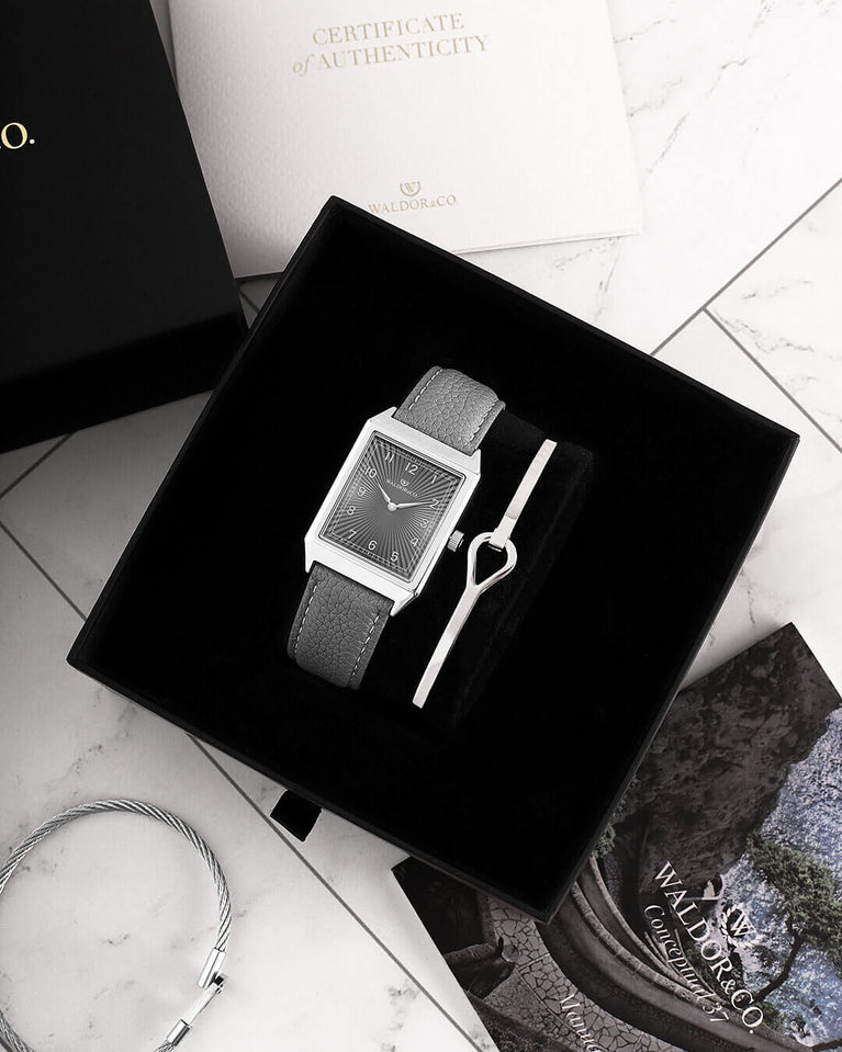 A square mens watch in Rhodium-plated 316L stainless steel from Waldor & Co. with grey guilloche dial. Miyota movement. Leather strap. The model is Conceptual 37 Cap Ferrat.