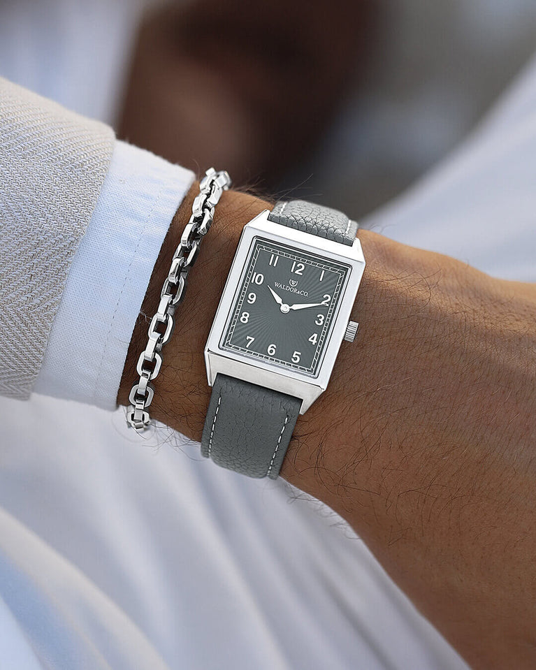 A square mens watch in Rhodium-plated 316L stainless steel from Waldor & Co. with grey guilloche dial. Miyota movement. Leather strap. The model is Conceptual 37 Cap Ferrat.
